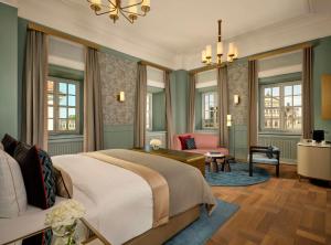 a bedroom with a large bed and a living room at Hotel Taschenbergpalais Kempinski in Dresden
