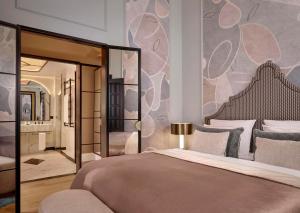 a bedroom with a large bed with a large mirror at Hotel Taschenbergpalais Kempinski in Dresden