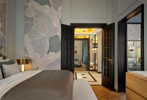 a bedroom with a king sized bed and a hallway at Hotel Taschenbergpalais Kempinski in Dresden