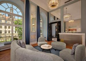 a living room with two couches and a table at Hotel Taschenbergpalais Kempinski in Dresden