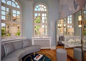 a living room with a couch and some windows at Hotel Taschenbergpalais Kempinski in Dresden