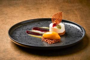 a black plate with some food on a table at Hotel Taschenbergpalais Kempinski in Dresden