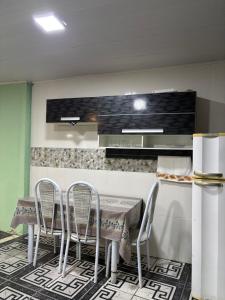 une cuisine avec une table, des chaises et un comptoir dans l'établissement Kitnet Maria Bonita - Cabo frio, à Cabo Frio