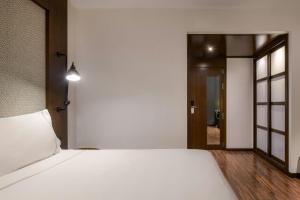 ein Schlafzimmer mit einem weißen Bett und einem Flur in der Unterkunft AC Hotel by Marriott Alicante in Alicante