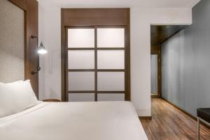 ein Schlafzimmer mit einem weißen Bett und einer Schiebetür in der Unterkunft AC Hotel by Marriott Alicante in Alicante + 37 Fotos