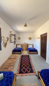 a bedroom with two beds and a rug on the floor at Quadruple room in fisherman house in Wassane