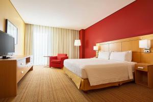a hotel room with a bed and a red wall at Courtyard by Marriott Leon at The Poliforum in León