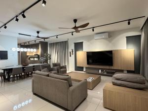 瓜埠Ruma Langkawi的带电视的客厅和用餐室