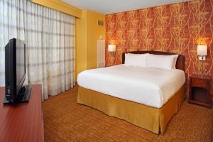 a hotel room with a bed and a flat screen tv at Courtyard by Marriott Baltimore Downtown Inner Harbor in Baltimore