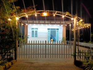 a white house with lights on a gate at night at Homestay Vạn Hưng in Vạn Ninh +6 photos