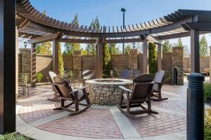 a patio with a table and chairs under a pergola at Courtyard by Marriott Asheville Airport in Arden