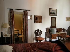 a bedroom with a bed and a desk with a television at Solar das Avencas in Portalegre