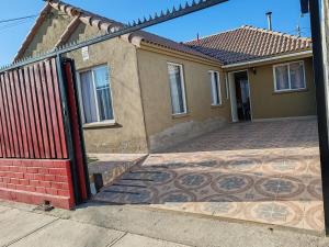 a house with a red gate and a brick driveway at La Serena casa Puertas del Mar cerca del Faro in La Serena