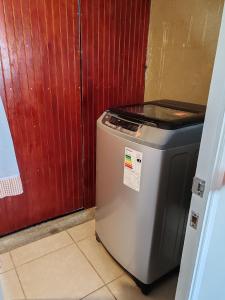 a small refrigerator sitting next to a red door at La Serena casa Puertas del Mar cerca del Faro in La Serena