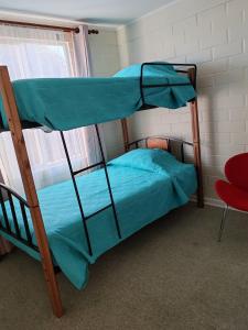 two bunk beds in a room with a red chair at La Serena casa Puertas del Mar cerca del Faro in La Serena