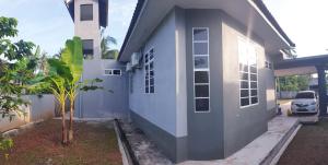 a blue and white house with a car parked outside at Cikteh Homestay Besut in Kampung Raja
