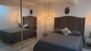 a bedroom with two beds and a mirror at amplio y comodo apartamento in Medellín