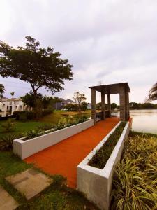 a garden with a walkway next to a body of water at Cheery Room 203 in Surabaya