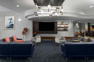 バーバンクにあるCourtyard Los Angeles Burbank Airportのソファと薄型テレビのある待合室