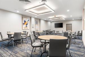 a conference room with tables and chairs and a screen at Holiday Inn Express Van Nuys by IHG in Van Nuys +29 photos