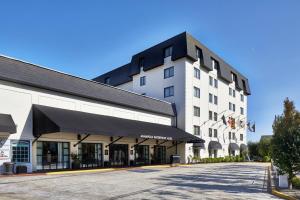 a large white building with a black awning next to a street at Annapolis Waterfront Hotel, Autograph Collection in Annapolis