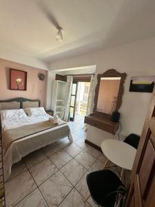 サン・フランシスコ・ド・スルにあるPousada Farol da Ilhaのベッドとテーブルと鏡のある寝室