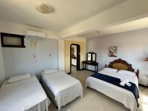 サン・フランシスコ・ド・スルにあるPousada Farol da Ilhaのベッドが2つと鏡があるホテルの部屋