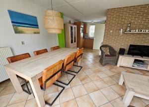une table à manger et des chaises dans un salon dans l'établissement Prachtige vakantiewoning-6P-afgesloten tuin-2 fietsen-dichtbij het strand, à Julianadorp