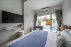 a bedroom with a bed and a view of a pool at Laguna Beach Villa Phuket 207byน้องมังคุด in Ban Pak Lak +24 photos