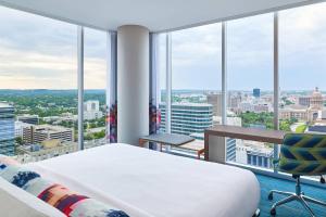 a bedroom with a bed and views of a city at Aloft Austin Downtown in Austin +37 photos