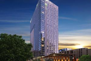 a tall building with a sunset in the background at Aloft Austin Downtown in Austin