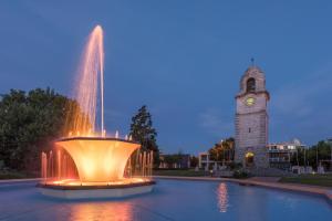 a water fountain with a clock tower in the background at Lugano Motor Lodge in Blenheim