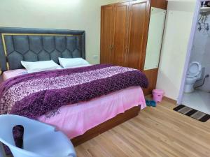 a bedroom with a purple bed and a toilet at Shimla Vibes B & B free pick and drop from ISBT Shimla in Shimla