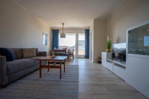 ein Wohnzimmer mit Couch und Fernseher in der Unterkunft Wohnung Krabbenkutter mit sonnigem Südbalkon! in Büsum
