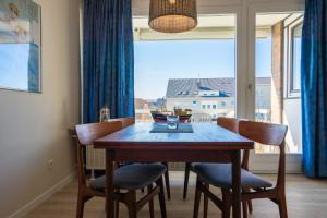 ein Esstisch mit Stühlen und ein Fenster in der Unterkunft Wohnung Krabbenkutter mit sonnigem Südbalkon! in Büsum