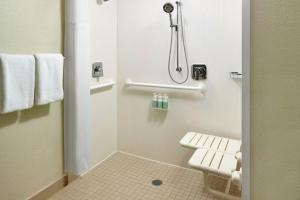 a small bathroom with a shower and a toilet at Courtyard by Marriott Atlanta Airport South/Sullivan Road in Atlanta +24 photos