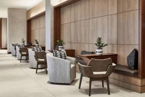 a row of chairs and tables in a hotel lobby at AC Hotel by Marriott Atlanta Airport Gateway in Atlanta