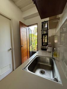 a kitchen with a stainless steel sink in a kitchen at Budget AC WI-FI Natl Road Ligao City Rm306 in Ligao