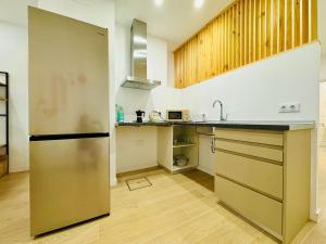 a kitchen with a stainless steel refrigerator and wooden floors at LOFT 1 - Space & Conform Close To Center in Valencia