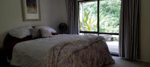 a bedroom with a bed and a large window at Cosy Unit 3 bdrms Two dogs live onsite with me in Waipapa +75 photos