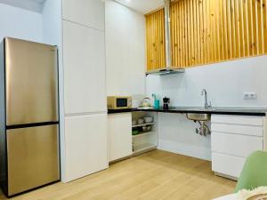 a kitchen with white cabinets and a stainless steel refrigerator at LOFT 2 - Space & Conform Close To Center in Valencia +17 photos