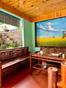 a restaurant with benches and a large painting on the wall at Viena Homestay in Bắc Hà