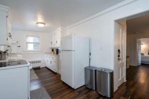 a kitchen with a white refrigerator and a table at 2-Bedroom Apartment, Historic Carriage House in Manchester