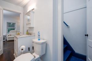 a white bathroom with a toilet and a sink at 2-Bedroom Apartment, Historic Carriage House in Manchester +18 photos