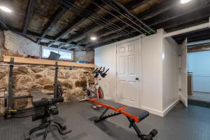 a room with a gym with a stone wall at 2-Bedroom Apartment, Historic Carriage House in Manchester