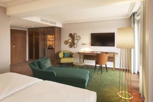 een hotelkamer met een bed, een bureau en een bank bij Falkenstein Grand, Autograph Collection in Königstein im Taunus