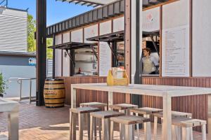 einen Tisch und Stühle vor einem Restaurant in der Unterkunft Cozy Lake Escape near Parliament, Embassies, Golf Club in Yarralumla