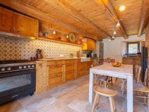 a kitchen with wooden cabinets and a table and a stove at Maison de village 8 personnes à Loudervielle avec Wifi - FR-1-695-71 in Loudenvielle +9 photos