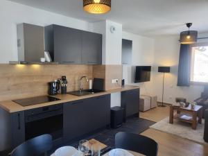 eine Küche mit einer Arbeitsplatte und ein Wohnzimmer in der Unterkunft Appartement neuf 3 pièces, vue piste, parking couvert - FR-1-291-1026 in Valmorel + 7 Fotos