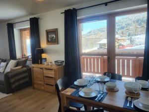 ein Esszimmer mit Tisch und ein Wohnzimmer in der Unterkunft Appartement neuf 3 pièces, vue piste, parking couvert - FR-1-291-1026 in Valmorel